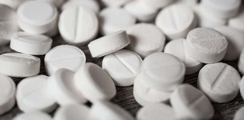 Antidepressant pills against a grey background.